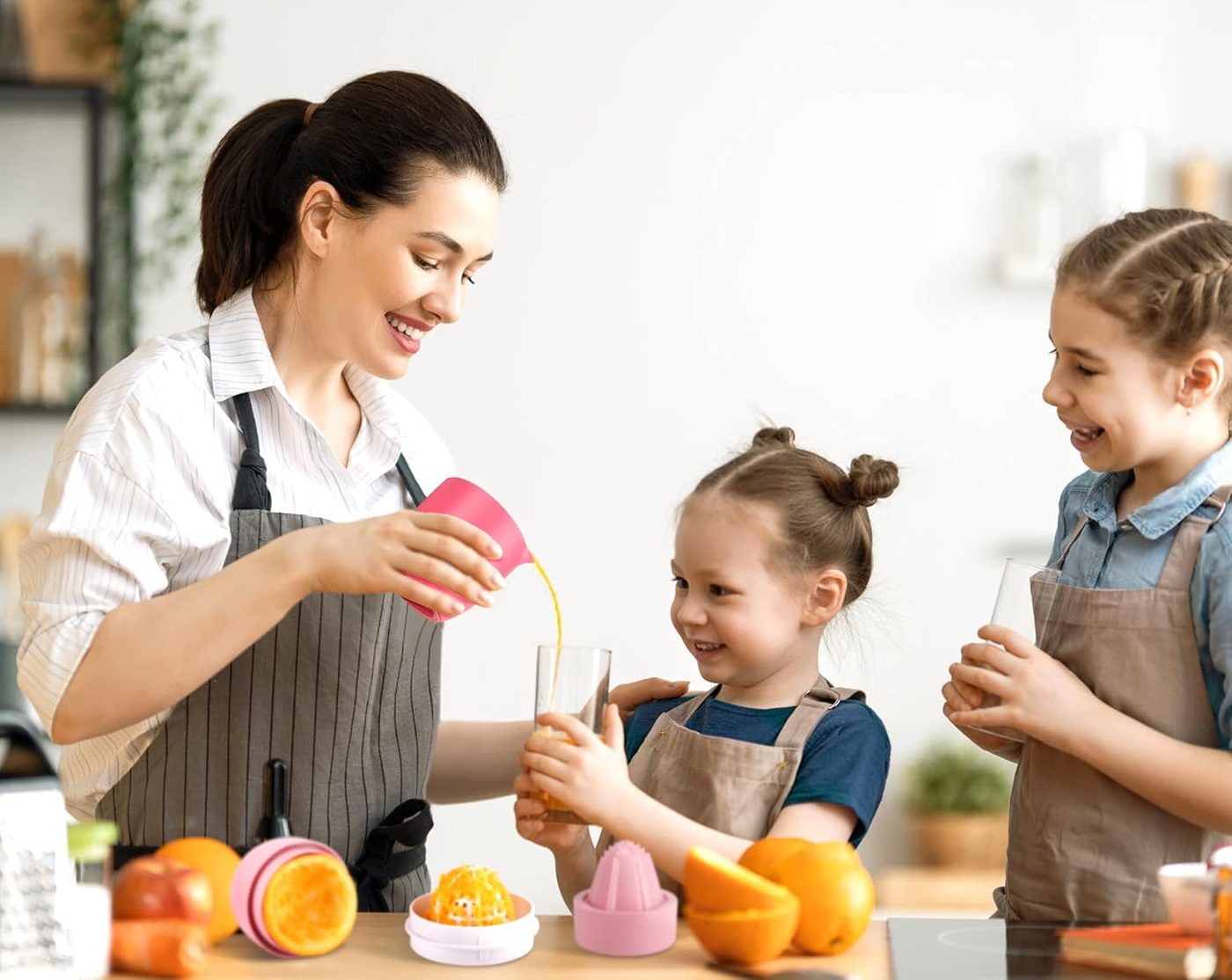 Family making orange juice with the pink Lechin hand juicer